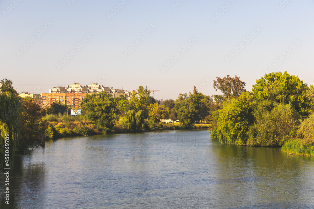 Village river at sunset, clear blue sky above