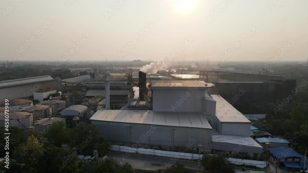 Ethanol industrial or biofuel refinery processing factory with smoke from chimney, storage tanks and warehouse Ethanol industrial or biofuel refinery processing factory with smoke from chimney, storage tanks and warehouse