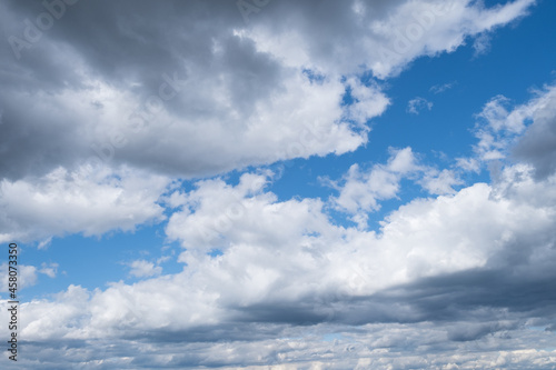 Blue sky background with white clouds close-up. Daylight of the sky. Natural composition of the sky. Design element. Vast blue sky. Copy space