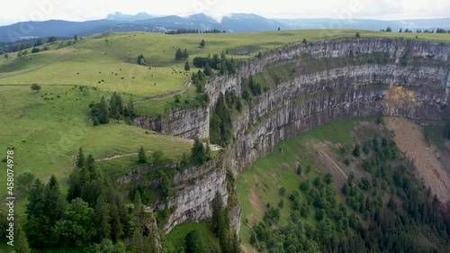 Descending drone shot of Creux du Van in Switzerland, located at the border of the cantons of Neuenburg and Vaud photo