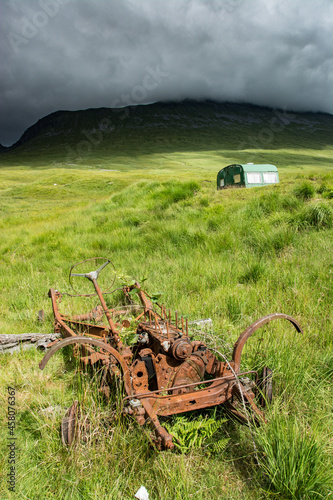 Along the West highland Way in Scotland. The rusty wreck of an old car was abandoned in a meadow photo