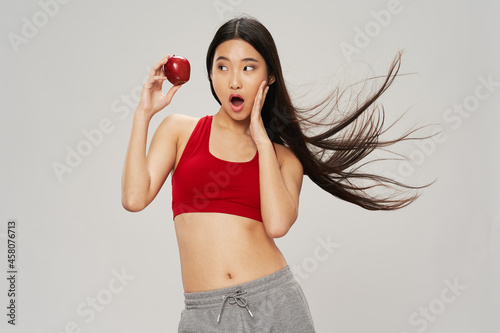 slender asian woman with apple in her hands diet health