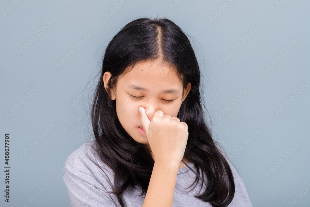 Eleven years old girl have symptoms of nasal congestion, try to squeeze her nose, have a stuffy nose Eleven years old girl have symptoms of nasal congestion, try to squeeze her nose, have a stuffy nose