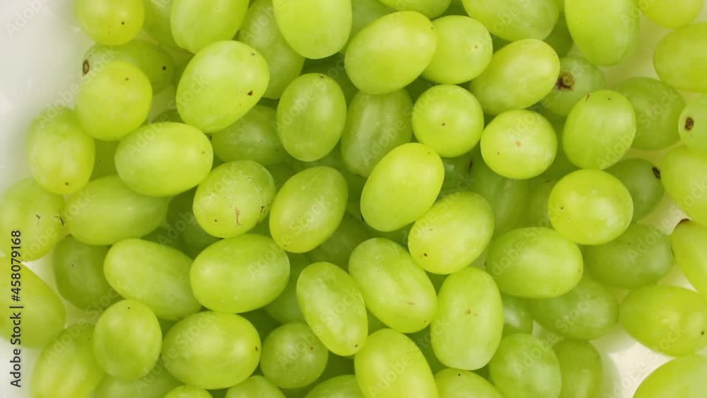 White bowl with fresh green grapes is rotating, top view footage White bowl with fresh green grapes is rotating, top view footage