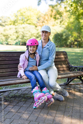 Mom and daughter in the park, girl on roller skates
