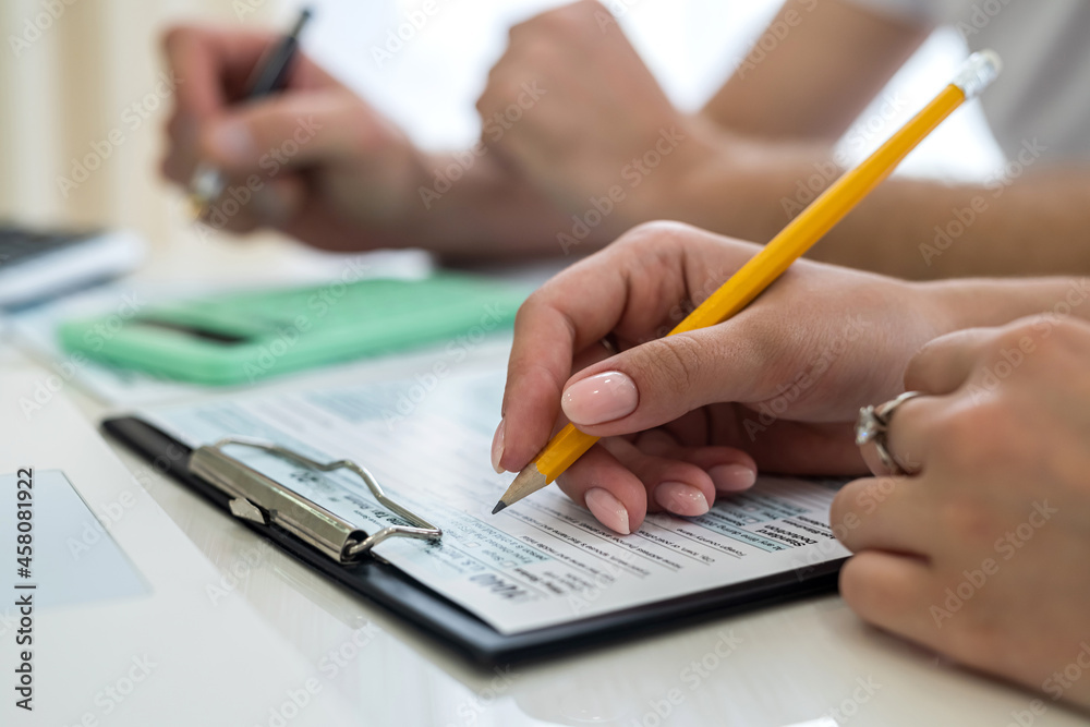 female hand filling us tax form, 1040 female hand filling us tax form, 1040