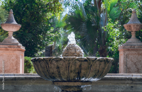 Close-up of a small stone fountain, in a romantic garden, on a fall or winter day.