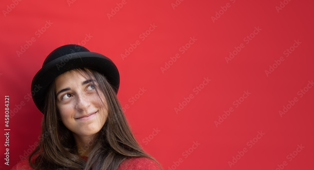 Teenager girl portrait on a red background. Horizontal photo, Christmas atmosphere with copy space