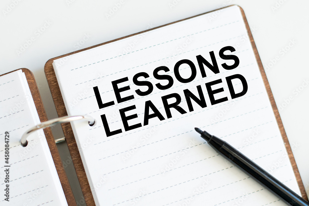 Lessons learned text concept write on notebook Lessons learned text concept write on notebook