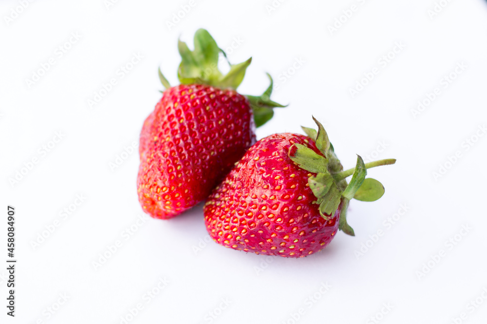 Two appetizing brightly red strawberries on a white background Two appetizing brightly red strawberries on a white background