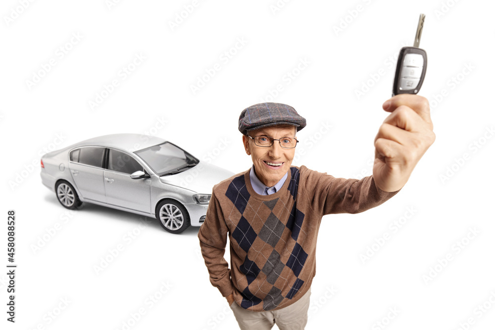 Elderly happy man with a new silver car showing a car key in front of camera Elderly happy man with a new silver car showing a car key in front of camera