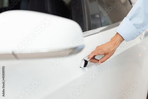 Close up woman caucasian customer buyer client female hand arm touch open door chooses auto wants to buy new automobile in car showroom vehicle salon dealership store motor show indoor. Sales concept