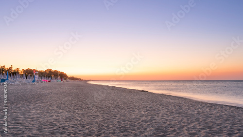 Panorama of adriatic sea and beach with umbrella at sunrise