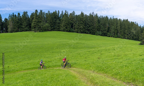 nice and remained young grandmother and her grandson riding their electrc mountain bikes in the Allgaeu Alps near Oberstaufen in Bavaria, Germany © Uwe