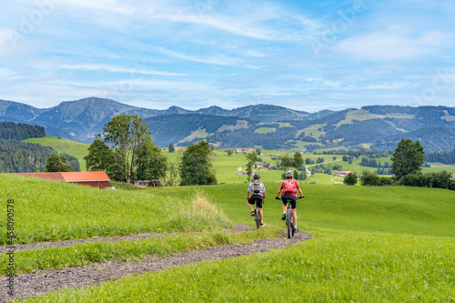 nice and remained young grandmother and her grandson riding their electrc mountain bikes in the Allgaeu Alps near Oberstaufen in Bavaria, Germany photo