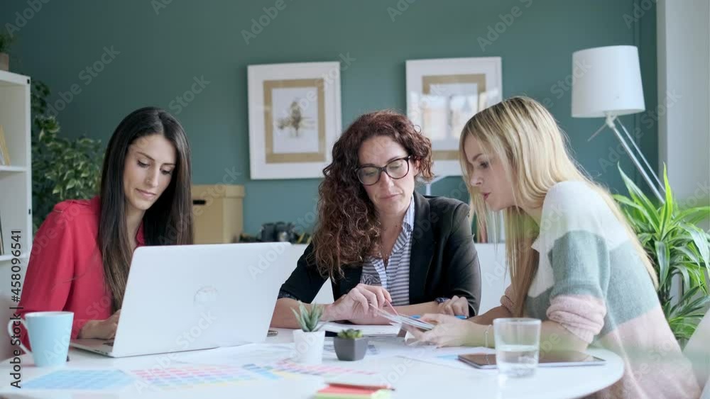 Video of group of multiage designer women working in a design project while choosing materials in the office. Video of group of multiage designer women working in a design project while choosing materials in the office.