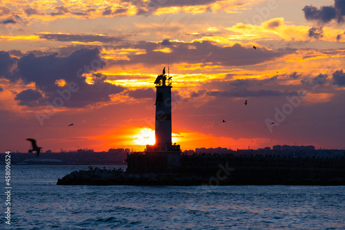 lighthouse and breakwater view. dramatic sunset. kadikoy, istanbul, turkey.