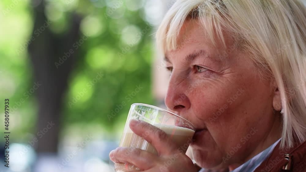 Close up portrait of happy blonde senior woman enjoying drinking aroma coffee with milk at the cafe in the morning. Close up portrait of happy blonde senior woman enjoying drinking aroma coffee with milk at the cafe in the morning.