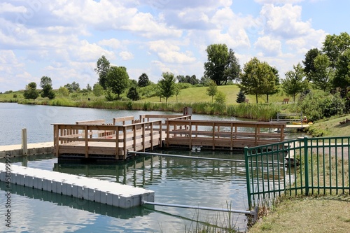 The wood fishing dock at the lake in the park.