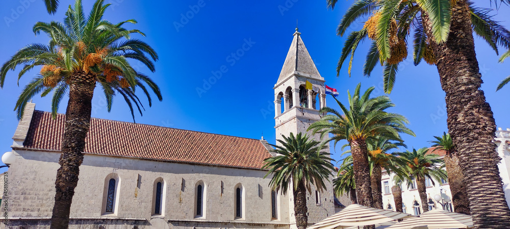 Historic City of Trogir. Old stone church St. Lawrence Cathedral (Katedrala sv. Lovro). Palms and Croatian flag. Dalmatia. Croatia. Europe	