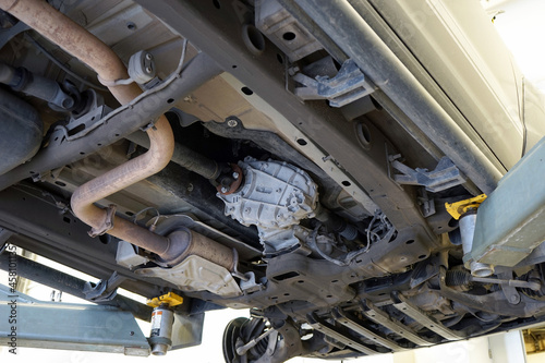 Modern car in a car service on a lift. Transfer case, muffler, exhaust pipe. Car service and repair.