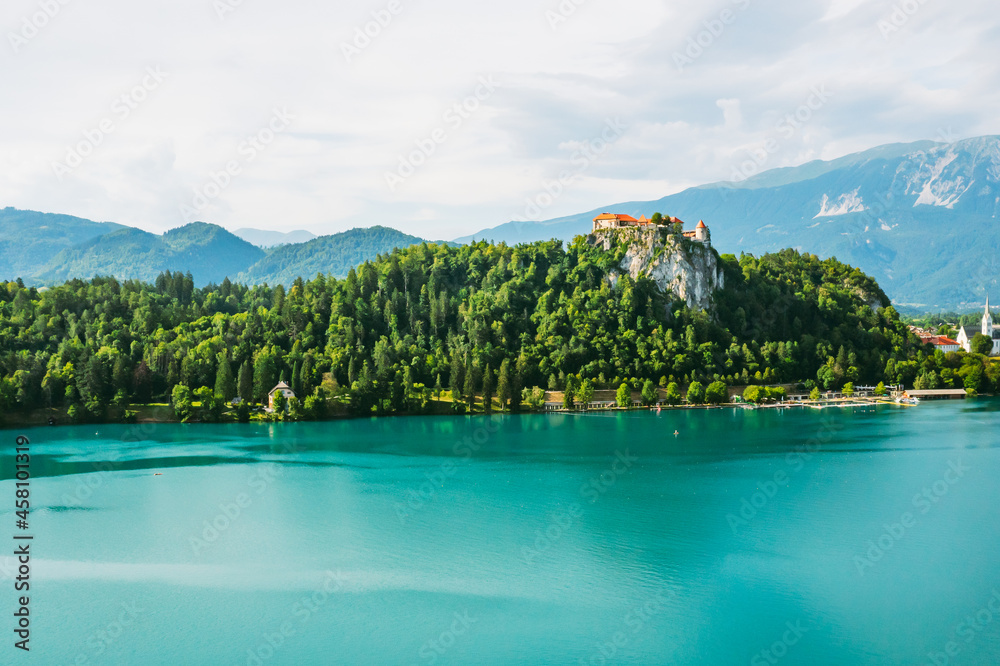 Mediaeval Bled castle on the cliff of the mountain under lake Bled with turquoise blue water in Slovenia