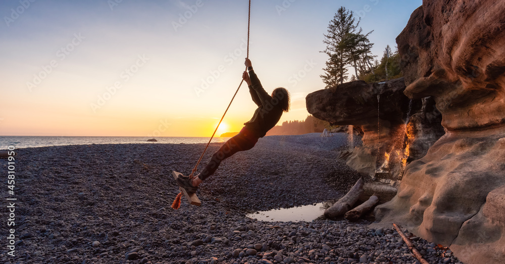 Fototapeta premium Adventurous White Caucasian Woman at Sandcut Beach on the West Coast of Pacific Ocean. Summer Sunny Sunset. Canadian Nature. Located near Victoria, Vancouver Island, BC, Canada.