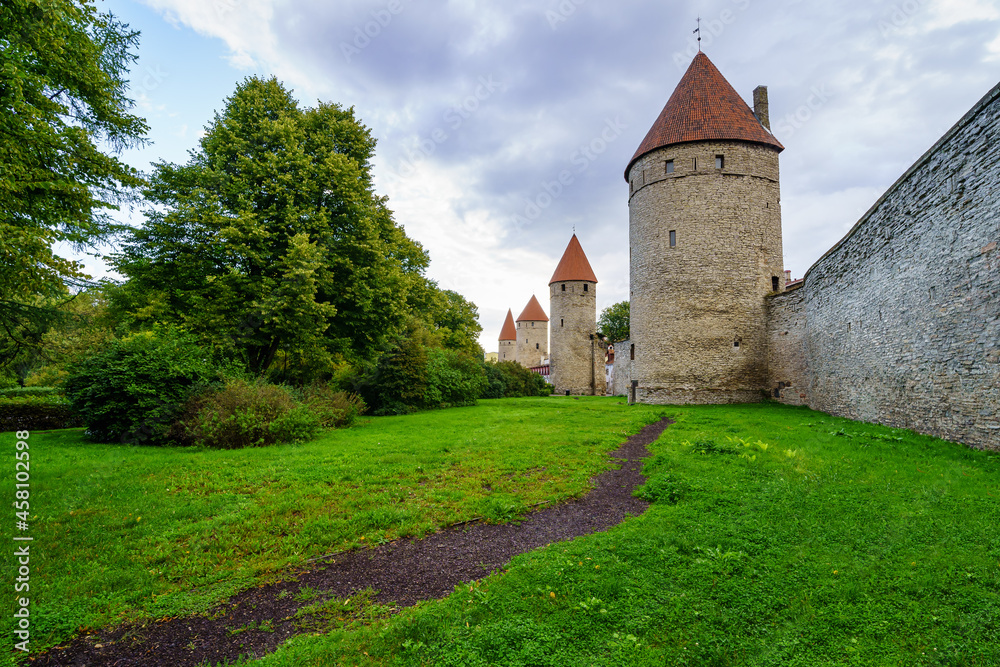 Medieval wall with tall stone towers and red roofs in Tallinn Estonia.