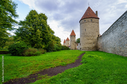 Medieval wall with tall stone towers and red roofs in Tallinn Estonia.