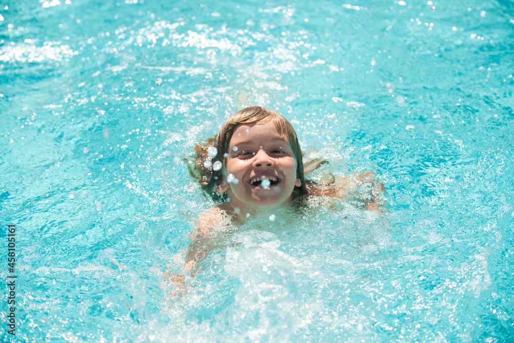 Cute child boy swim in swimming pool, summer water background with copy space. Funny kids face. Little boy playing in outdoor swimming pool in water on summer vacation. Child swim in outdoor pool.