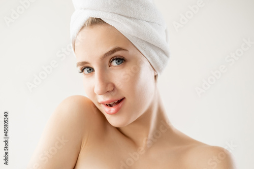 Skincare beauty. Flirting woman. Body treatment. Happy playful lady covering in towel posing isolated white.