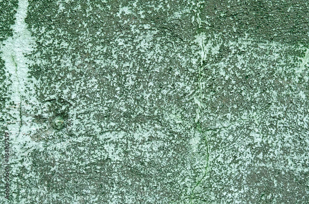 A concrete wall with remnants of green paint .Background
