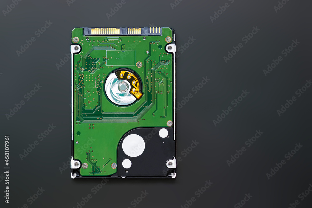 Green 2.5 inch hard disk drive from the computer, hdd isolated on dark background, top view. Part of computer pc, laptop Green 2.5 inch hard disk drive from the computer, hdd isolated on dark background, top view. Part of computer pc, laptop