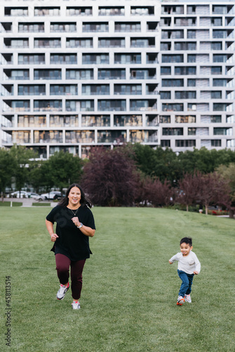 Mother and son running in field outside