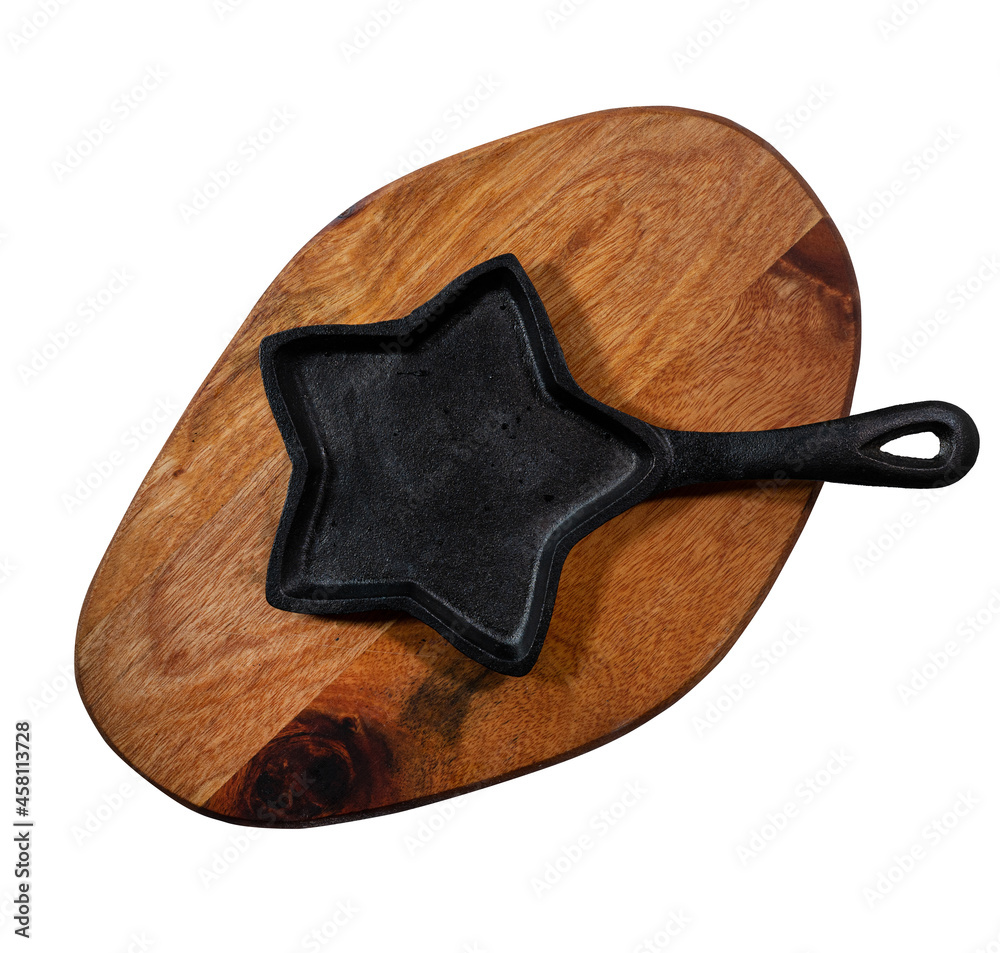 Flat lay of old wooden cutting board with black cast-iron frying pan in the shape of a five-pointed star isolated on white