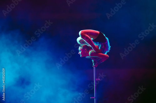 An aerial gymnast shows a performance in the circus arena. photo