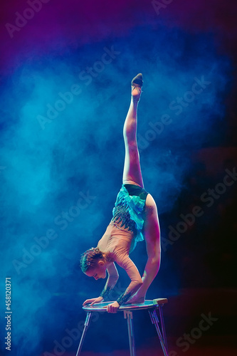 An aerial gymnast shows a performance in the circus arena.