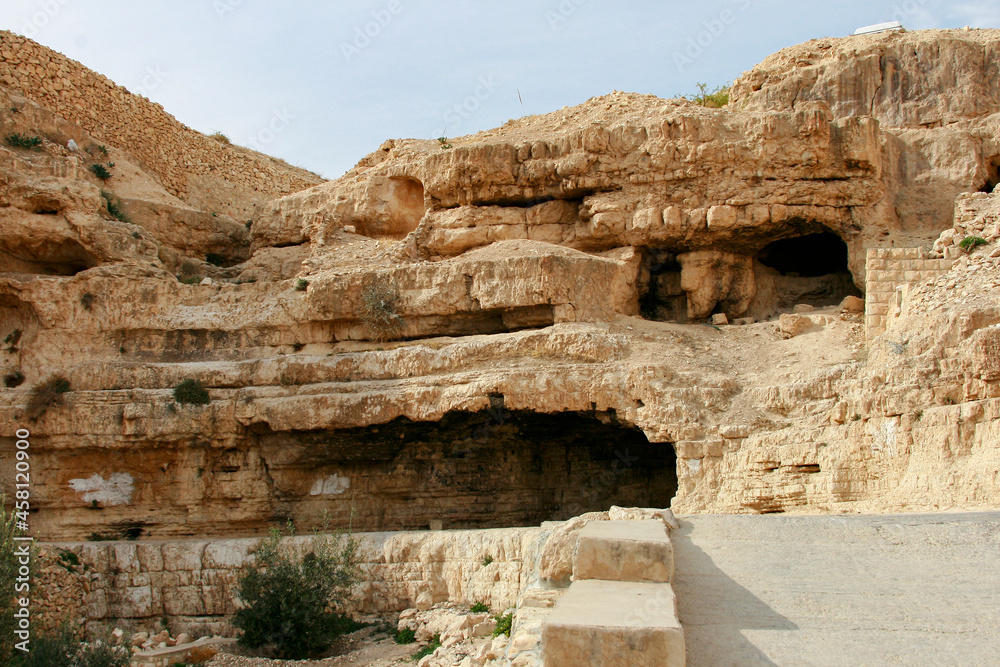 Orthodox Monastery of St. Sava the Blessed. Dome, cross, wall of the monastery. Mountains with caves of hermit monks and gorges The bottom of the stream Kidron. Jewish desert. Palestine, Israel.