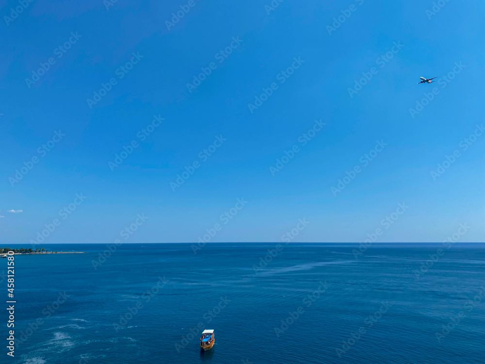 White sailing ship yacht at sea in shallow water near shore. Aerial drone view to sailboat