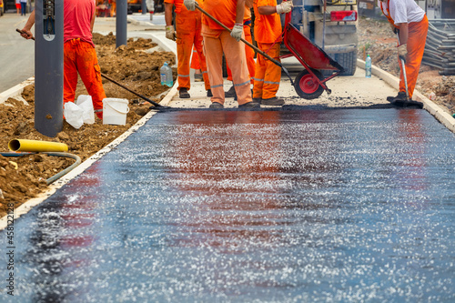 Fotografia Workers melting and placing asphalt pavement