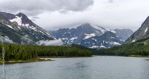 Mt. Gould and Angel Wing - A panoramic view of storm clouds hovering over Mt. Gould and Angel Wing at shore of Swiftcurrent Lake on a Spring morning. Many Glacier, Glacier National Park, Montana, USA. photo