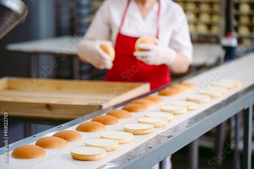 Conveyor belt in a bakery with newly baked buns.