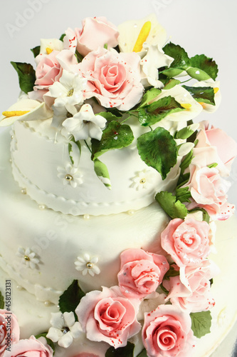 Beautiful wedding white cake with flowers on white