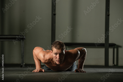 Strong male athlete doing push-ups indoors. Close up perspective, healthy lifestyle, fatless body.