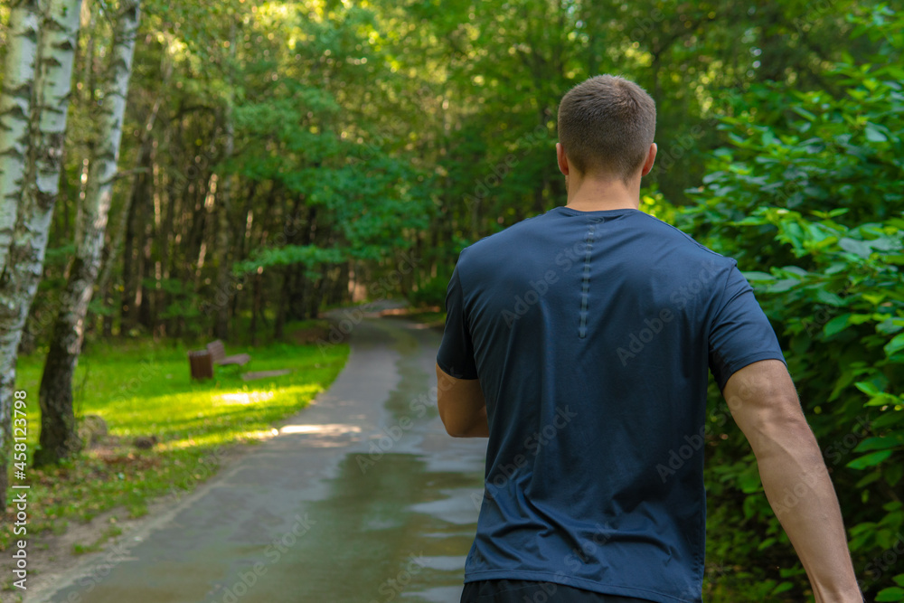 A man athlete runs in the park outdoors, around the forest, oak trees green grass young enduring athletic athlete healthy runner nature, workout young legs male, park wellbeing. cross, stretching A man athlete runs in the park outdoors, around the forest, oak trees green grass young enduring athletic athlete healthy runner nature, workout young legs male, park wellbeing. cross, stretching