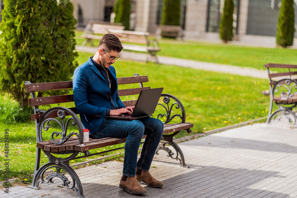 Young manager in blue suit on break using laptop for work Young manager in blue suit on break using laptop for work