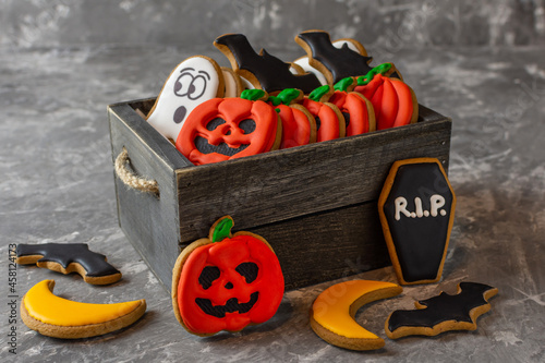 sweets gingerbread for halloween pumpkin ghost moon coffin bat in a wooden box on a gray stone background  photo