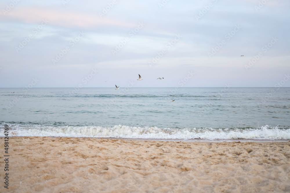 Beautiful sea summer abstract background. Golden sand beach with blue ocean and cloudscape and sunset in the back.