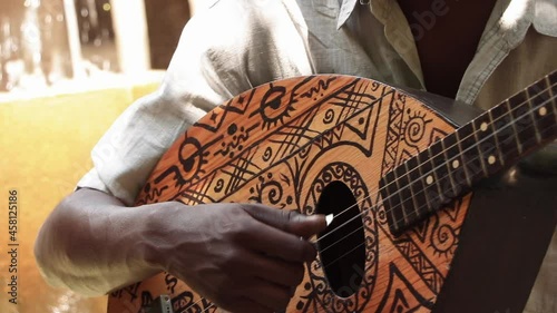 Photo of a person in the open air playing his guitar.