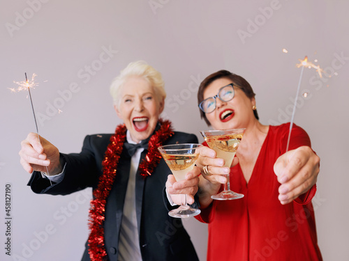 Two beautiful stylish mature senior women celebrating new year. Fun, party, style, celebration concept